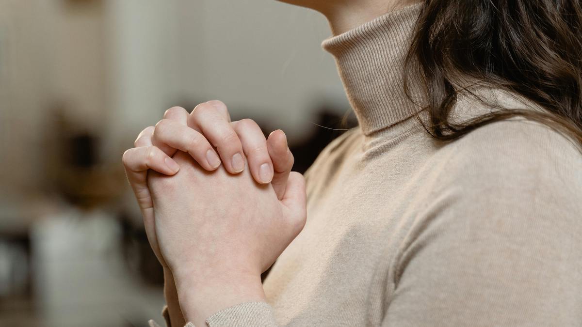 manos en actitud de oración de mujer blanca con pelo castaño para blog devocional cristiano sobre la presencia de Dios Dios con nosotros