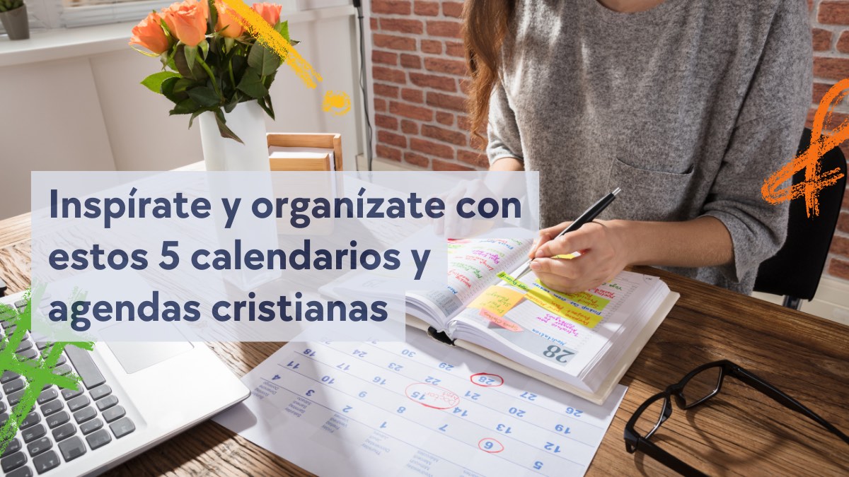 chica con jersey gris escribiendo en agenda y calendario en mesa de madera con portátil y detalle de florero con rosas naranjas para blog sobre agendas cristianas y calendarios