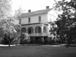 fotografia de la casa grande de dos plantas con porche con su jardín y arboles donde vivió E. M. Bounds en Georgia y que ahora es museo