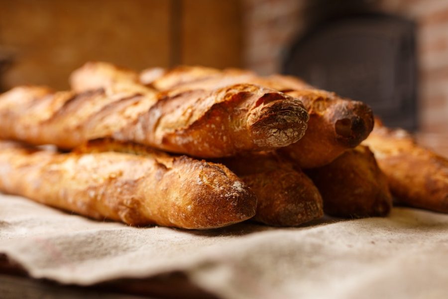 No solo de pan vive el hombre: 6 barras de pan recién horneadas descansan en un paño de cocina