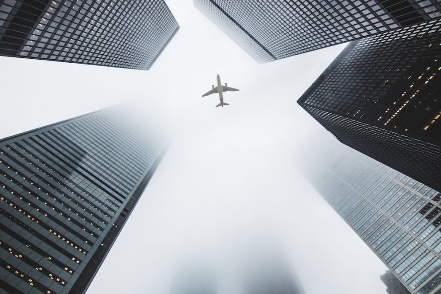 Tener fe: un avión cruza el cielo en medio de varios rascacielos