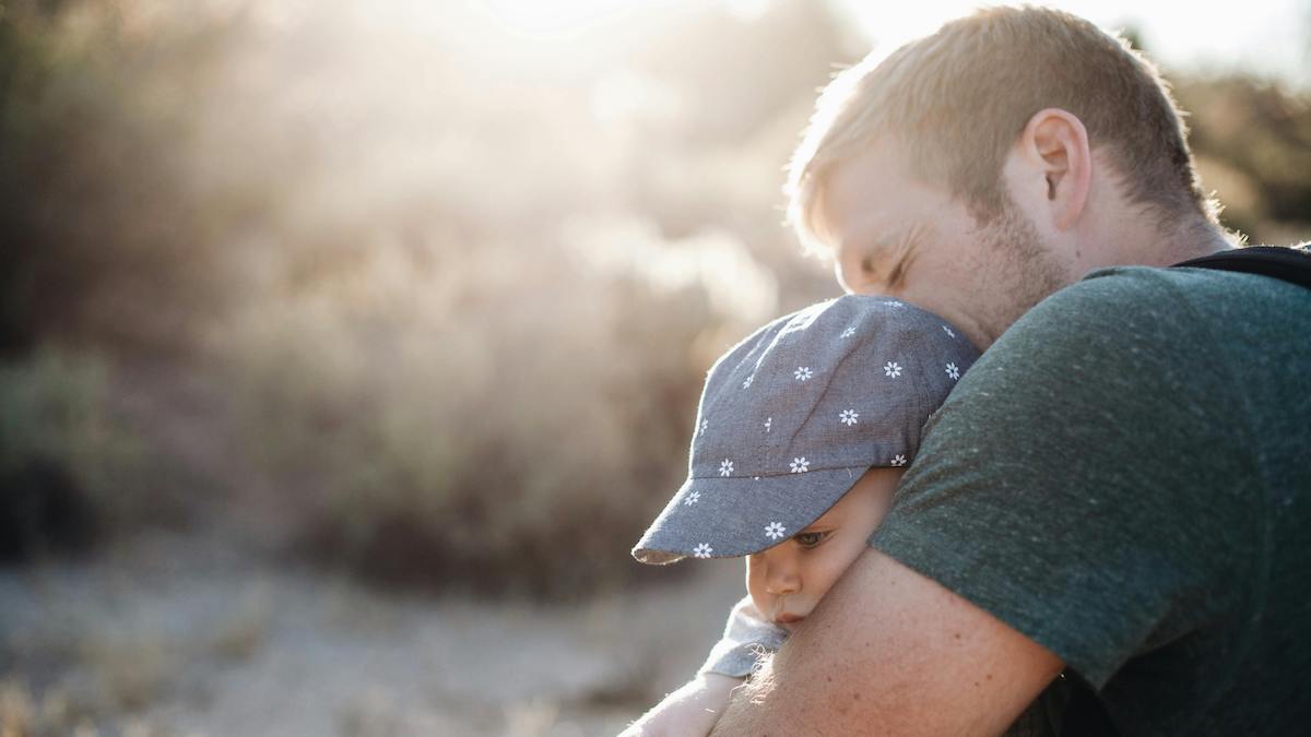 padre abraza a bebé para blog sobre el día del padre y recomendaciones de libros y regalos