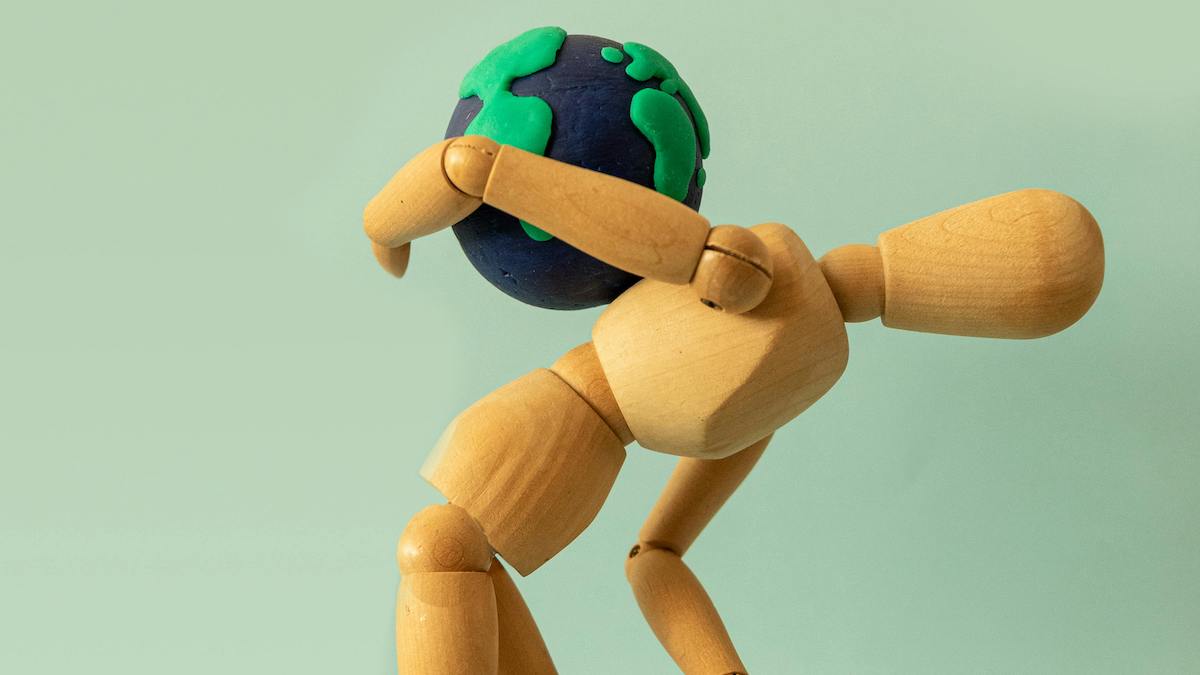 maniquí de madera lleva globo terráqueo a las espaldas para ilustrar blog sobre la preocupación y llevar la carga del mundo a nuestras espaldas